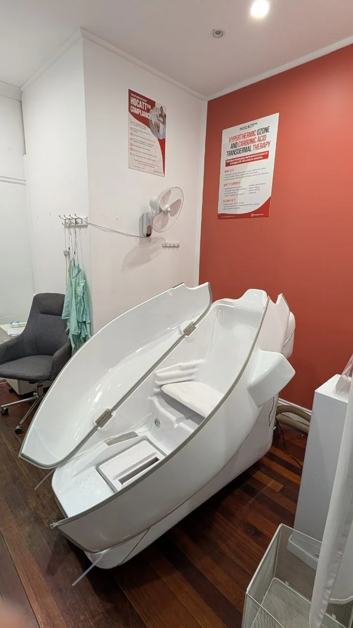 The open HOCATT sauna chamber in the red-and-white treatment room at Supercell Health.